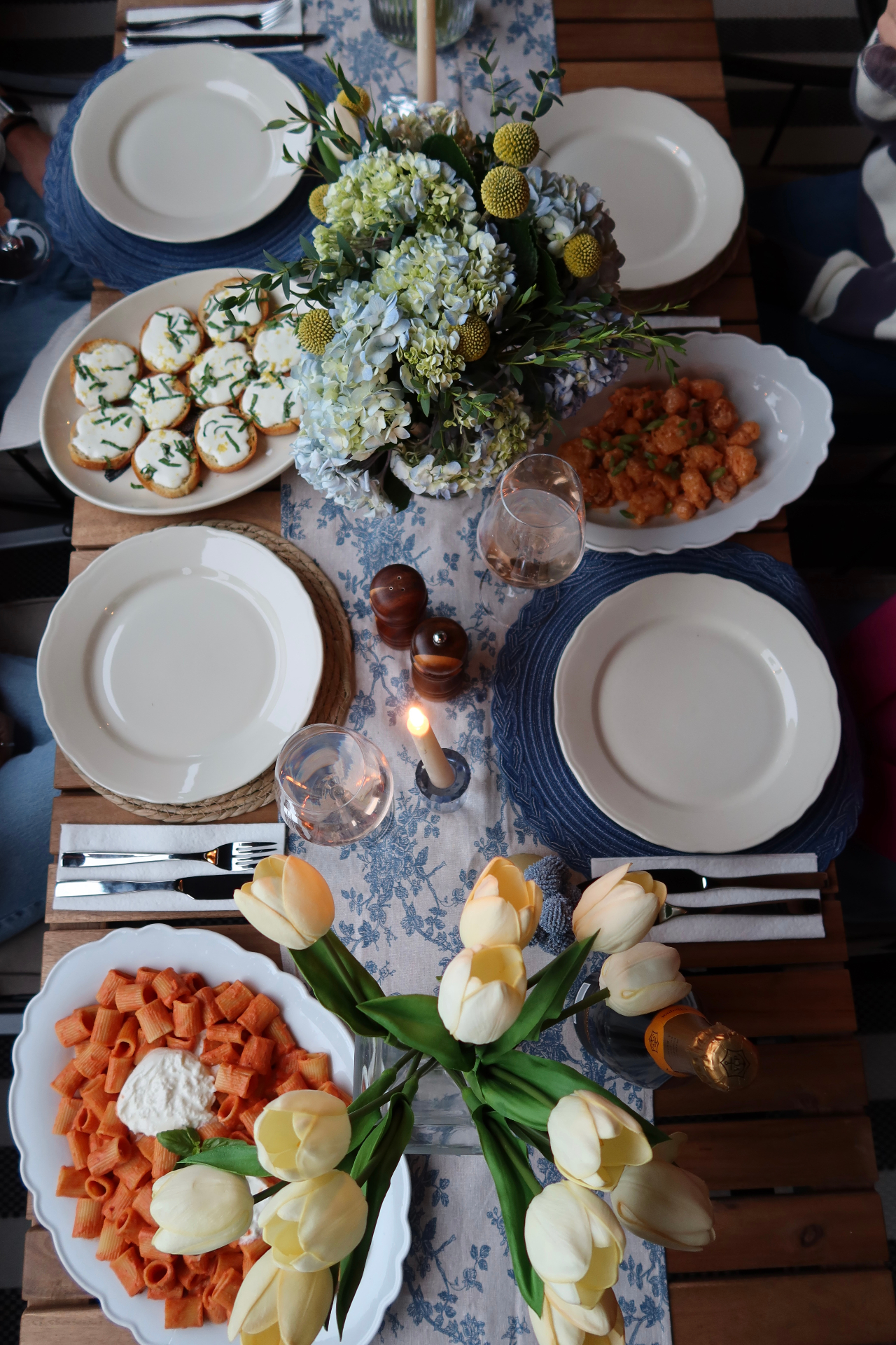 An intimate Charleston tablescape set with rigatoni, crostini, tulips and candlelight